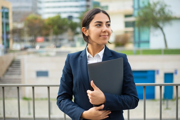 Confident Indian businesswoman holding a folder, symbolizing women's empowerment in commerce.